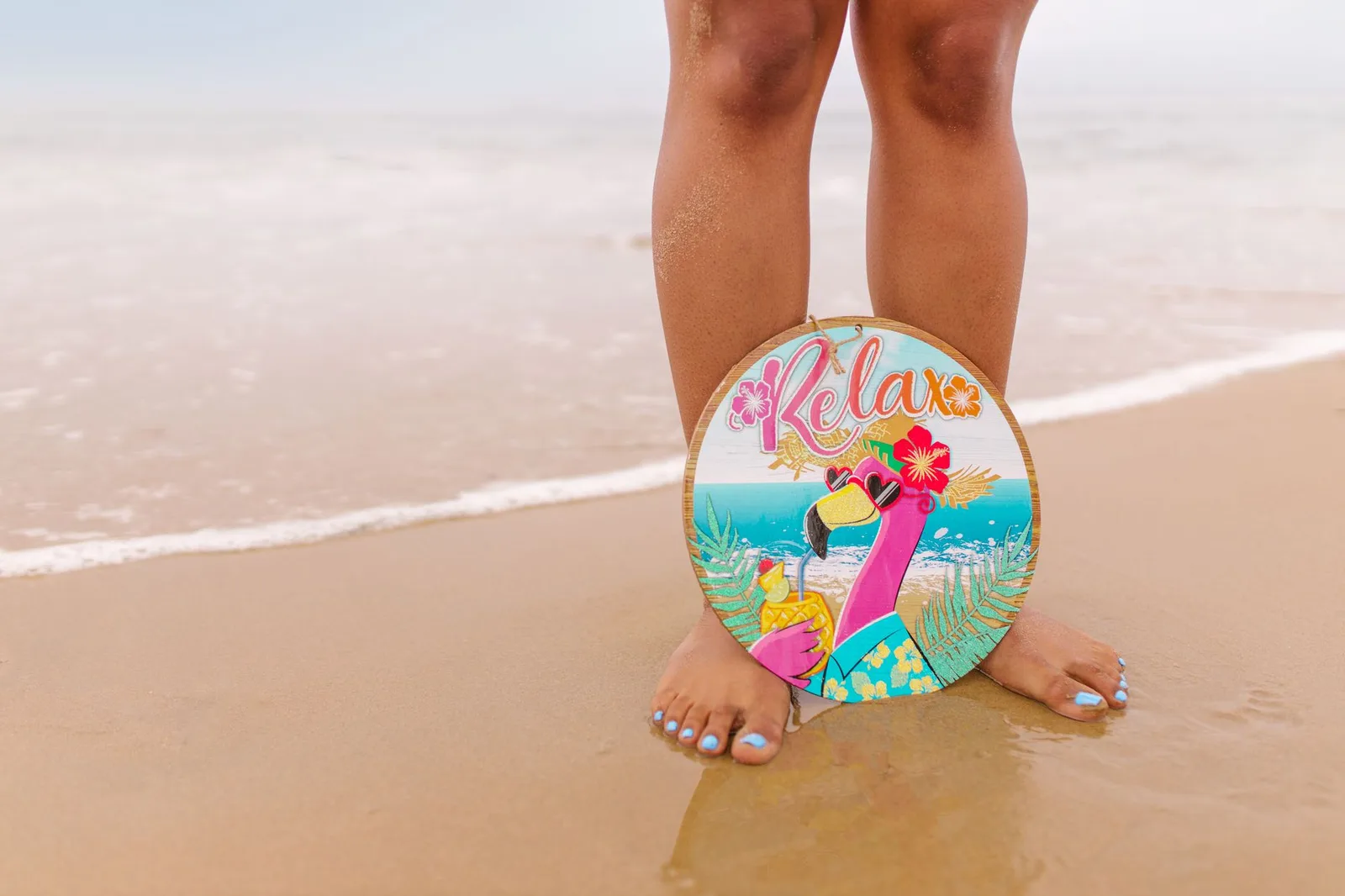 Sandy beach with colorful flamingo art and relaxing vibe.